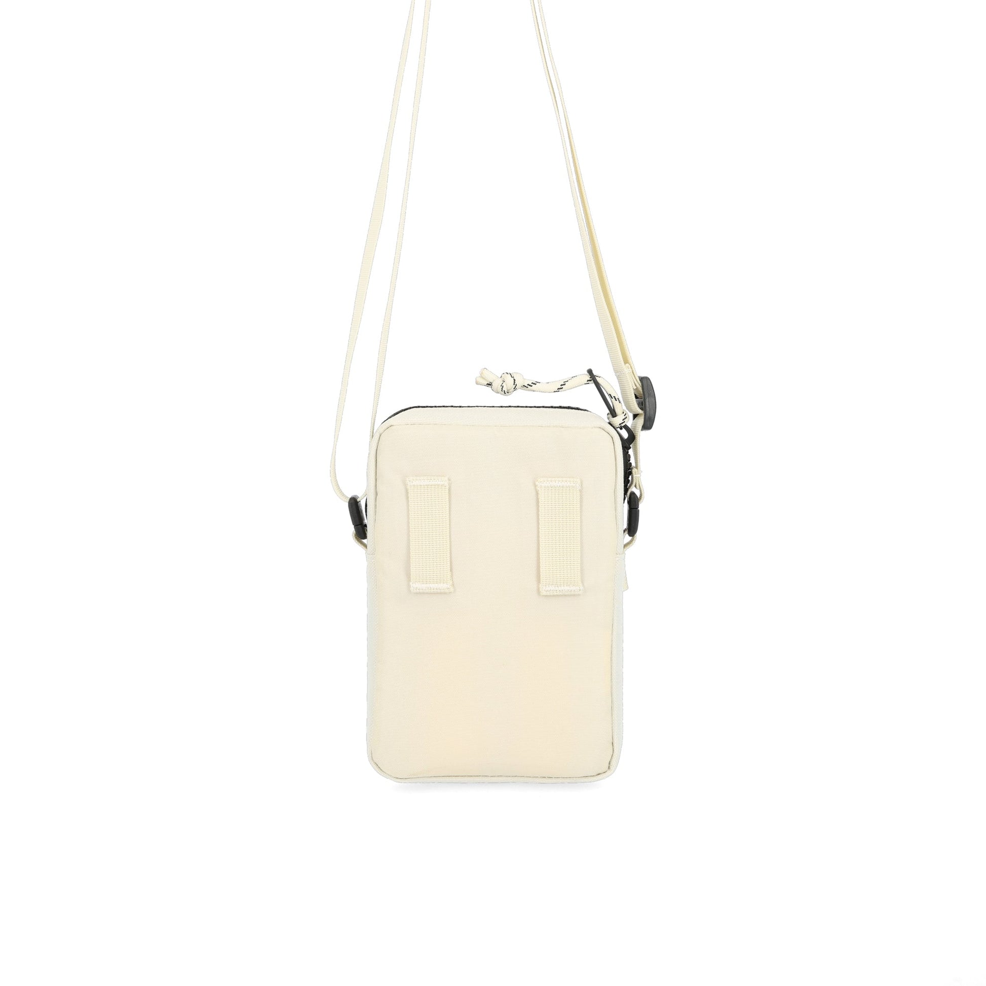 Back hip belt attachment points on Topo Designs Mini Shoulder Bag crossbody travel purse in "Bone White" recycled nylon.