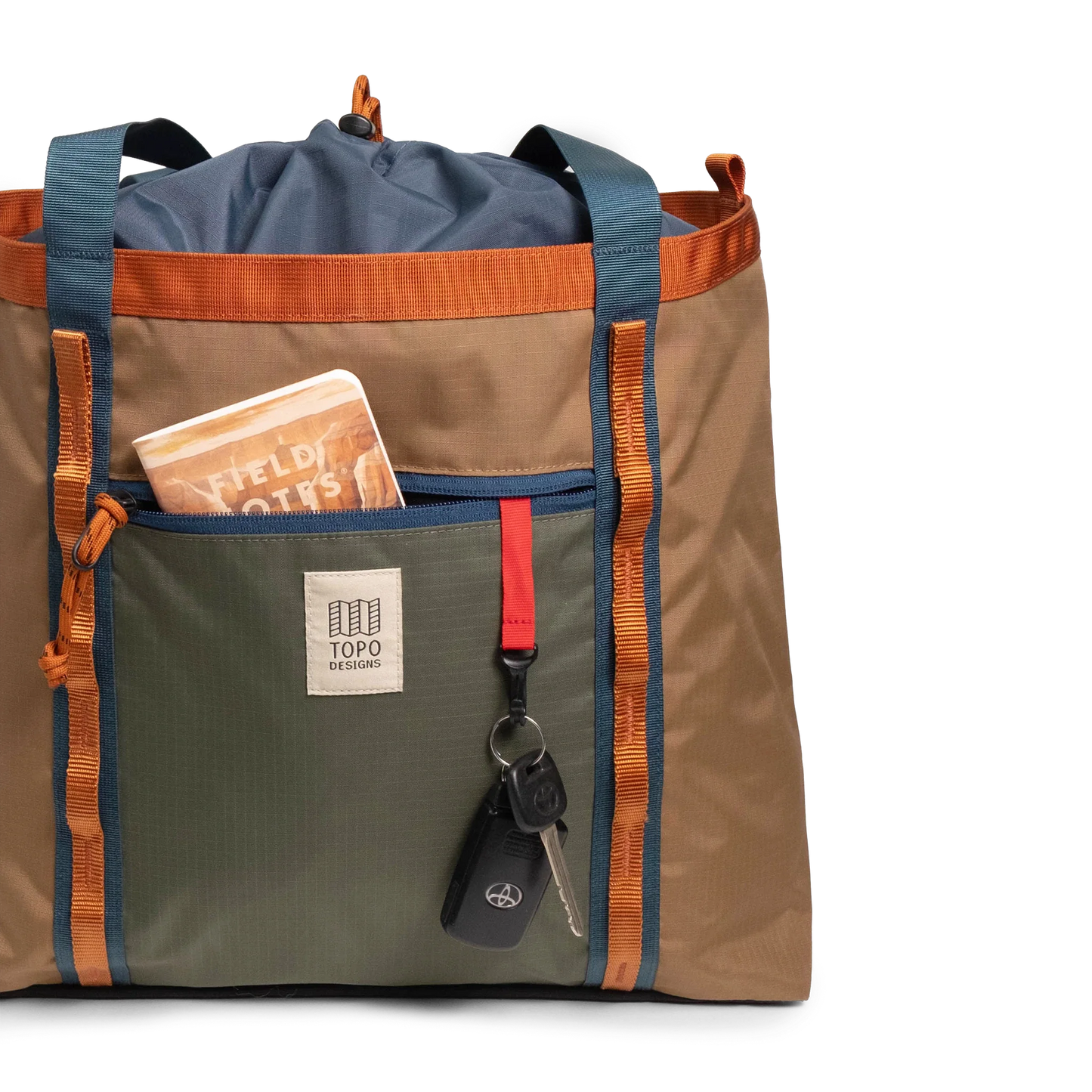 General front view of Topo Designs Mountain Utility Tote in "Olive / Dark Khaki" with notebook and keys.